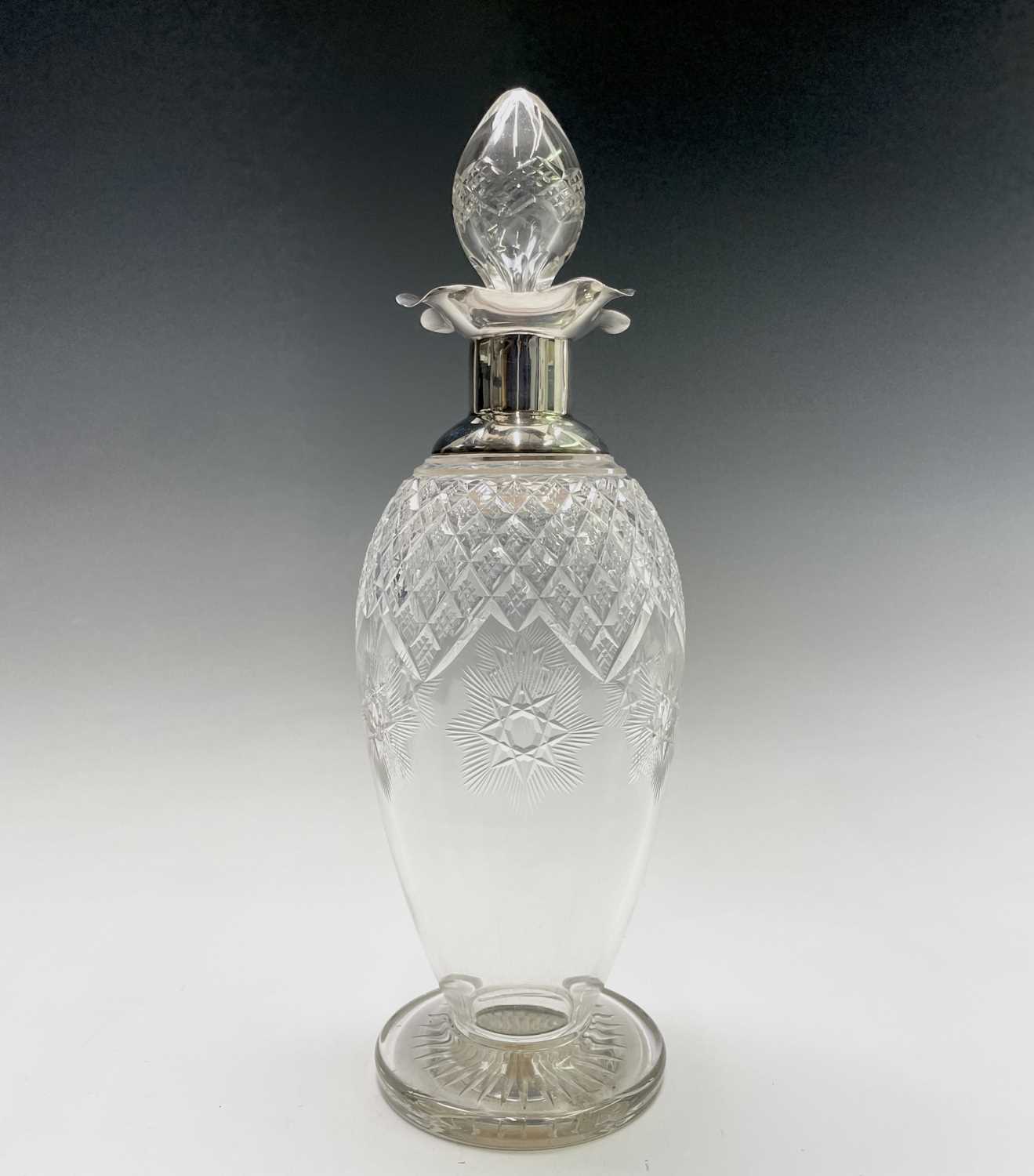 A good cut glass ovoid footed decanter with plain silver shoulder neck and quatrefoil rim by James