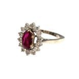An 18ct white gold ring set an oval ruby of approximately 1ct within a halo of 14 bright brilliant-