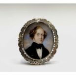 A Victorian chased gold memoriam brooch set with a portrait of a gentleman. To verso a hair panel
