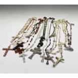 Fourteen rosary bead necklaces, all with unique crosses.