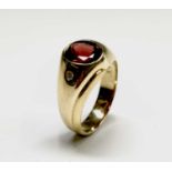 A ring (electronic test suggests 14ct) set with a red stone and two white stones 10gm Size V/