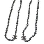 Chanel black pearl necklace. Very long black faux-pearl necklace with two pearl-set, gunmetal CC