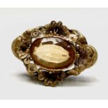 A Victorian gold filigree brooch set an oval citrine. The stone aproximately 10.75cts measures 19.