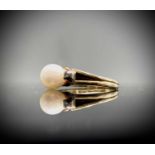 A pretty14ct ring, set a pearl with two tiny diamonds.Marked 585.