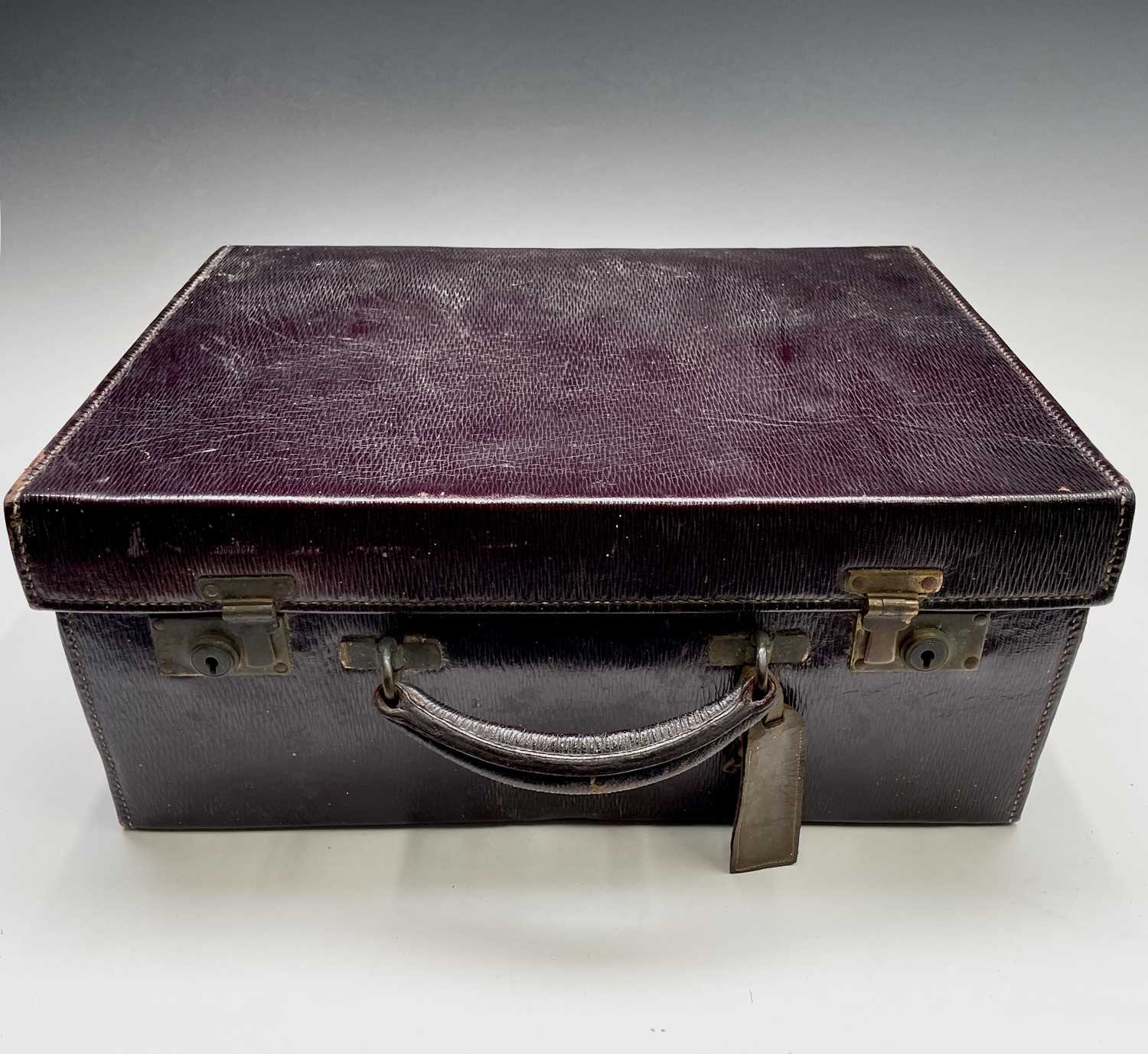 A purple leather toilet case by Mappin and Webb, the purple silk interior with silver-mounted