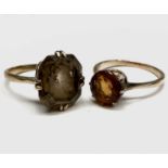 A gold ring set a circular orange/brown stone Size O and a gold ring set a rectangular smoke stone