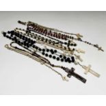 Ten rosary bead necklaces, five with bone crosses.