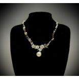 An opulent floral necklace set in silver with enamelled butterflies carved mother-of-pearl petals