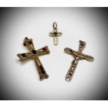 An 18ct gold garnet set cross, a tiny 18ct stone set cross 5.1gm and a 9ct crucifix 1.6gm