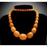 An amber necklace the largest bead 25.53mm wide, 75.9gmCondition report: This is likely to be