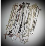 Fifteen rosary bead necklaces, all with unique crosses.