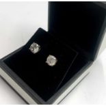 A pair of diamond earring studs each of about 1ct. ( one measures just under 1ct, the other just