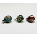 Three enamelled miniature eggs each with the arms of the Russian Empire, unmarked, each 16mm