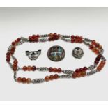 A silver and agate arts and crafts 92cm necklace, two silver-mounted brooches and an enamel gilt