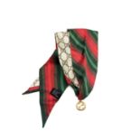 Gucci silk chokerSilk scarf choker in reds and greens with goldtone Gucci logo pendant. In brown