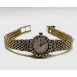 A ladies Bueche-Girod 9ct gold wristwatch with diamond-set bezel with 17 jewel movement,