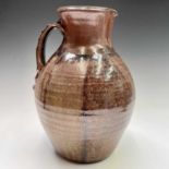 A large studio pottery brown glazed jug, height 32cm.