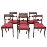 A set of four Regency mahogany dining chairs with carved cresting rails, drop-in seats on sabre