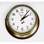 A brass cased ships bulkhead wall clock, the 7.25" dial signed SMITHS ASTRAL, upon mahogany
