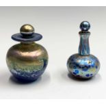 Two Norman Stuart Clarke iridescent glass scent bottles and stoppers, one is ovoid with a wave