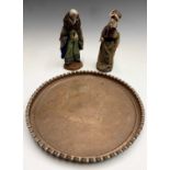 A pair of terracotta figures dressed in handmade clothes, height 26cm, together with a circular