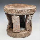 A carved circular stool, Cameroon, Bamileke, with dished top on carved slightly concave supports,