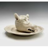 A porcelain tureen and cover in the form of a boar's head on a platter, circa 1800. Diameter 21cm.