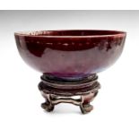 A Ruskin high-fired bowl, sang de boeuf glaze with incised border, repeated to the matching