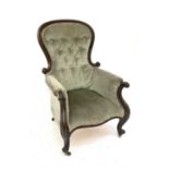 A Victorian walnut framed button back armchair, with scroll end arms and raised on cabriole front