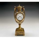 A French Empire ormolu cased mantel clock, of urn form, the covered rim applied with two winged