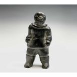 An Inuit and carved stone figure, probably early 20th century, of a standing male. Height 14.5cm.