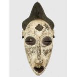 An African tribal carved and painted wood mask. Height 46cm.