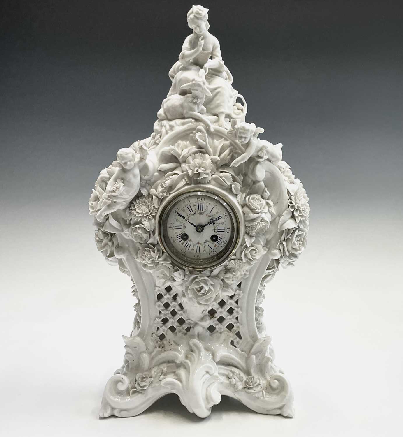 A 19th century French porcelain cased mantel clock by Vion & Baury, surmounted by a shepherdess,