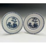 A pair of Delft blue and white plates, late 18th century, painted with bamboo and a peony in a