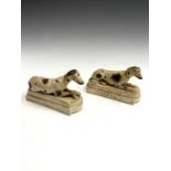 A pair of 19th century English porcelain figures of recumbent hounds, on stepped bases, length 15.