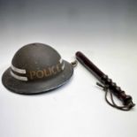 A WWII steel police helmet, together with a police truncheon, stamped CP below a crown, length