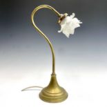 A brass swan neck desk or table lamp, early 20th century, with moulded glass flowerhead shade and on