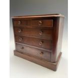 A Victorian mahogany miniature chest of two short and three long drawers, with turned knobs, on a