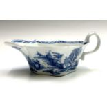 A good Bow sauceboat circa 1750, underglaze painted in blue with buildings in a rural landscape.