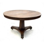 A William IV rosewood circular table, raised on an inverted octagonal pillar and triform base with