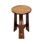 An Arts and Crafts Liberty oak occasional table, raised on three pierced and flared supports,