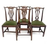 A pair of late George III mahogany dining chairs in the Chippendale style, together with another