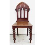 A Victorian mahogany hall chair, the back pierced with Gothic arches and tracery above a solid