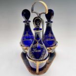 A set of three 19th century Bristol blue gilt decorated glass decanters with stoppers, inscribed '