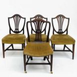 A set of three late George III mahogany dining chairs, of Hepplewhite style, the pierced splat