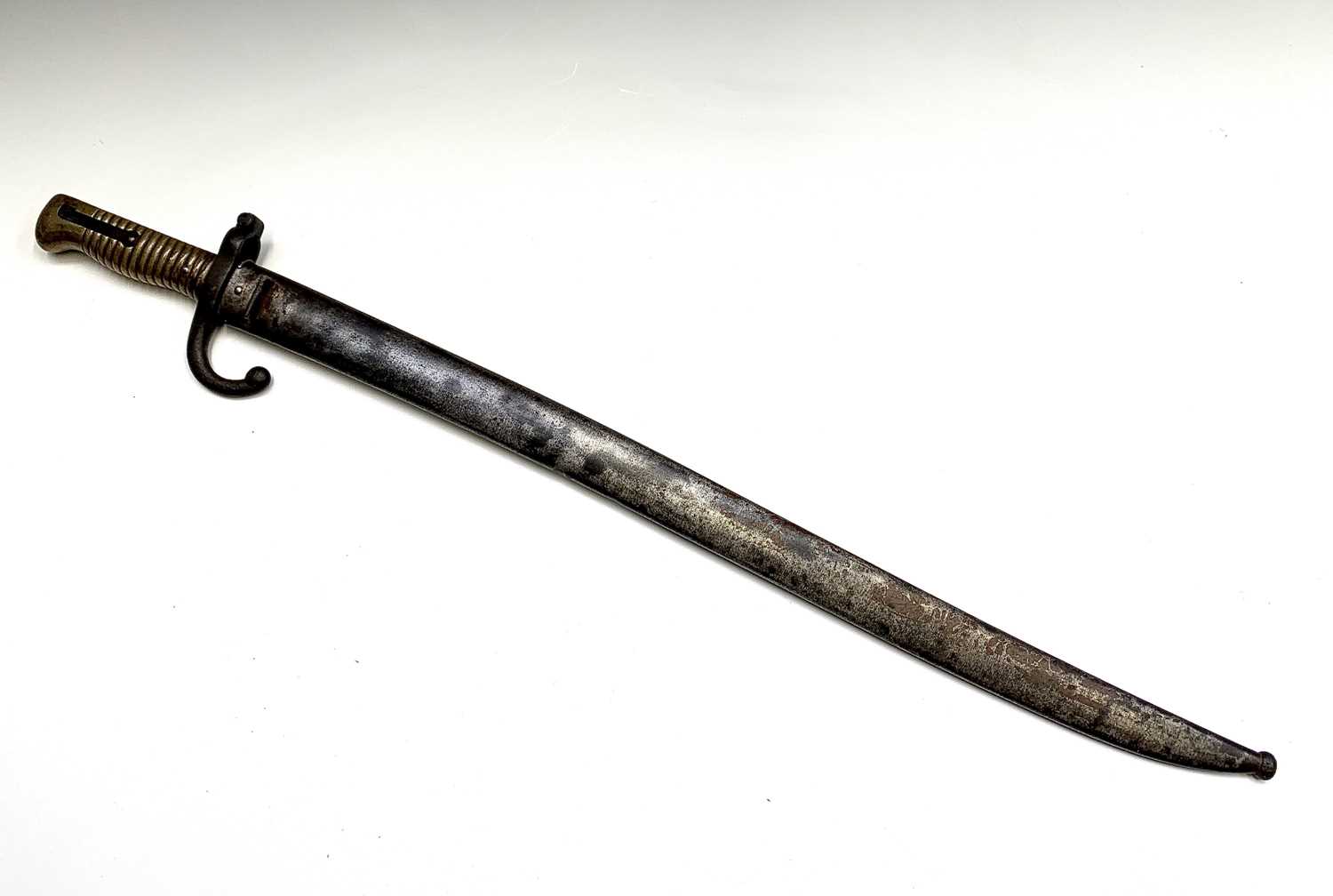 A French 1874 pattern bayonet, with brass grip, the blade inscribed St Etienne and contained in a