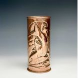 A Newlyn copper cylindrical vase, repousse decorated with two fish. Height 17.5cm.