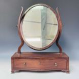 A George III mahogany and chevron banded toilet mirror, the serpentine base fitted a single