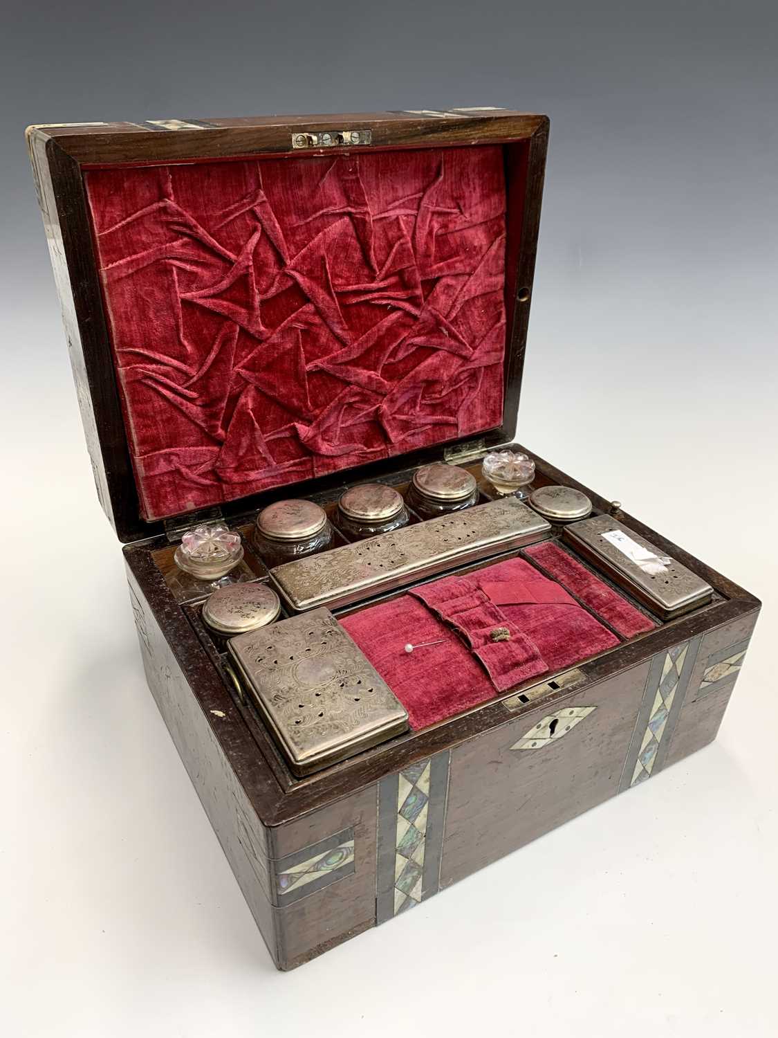 A Victorian rosewood, mother of pearl and abalone inlaid vanity box, fitted with jars and boxes with