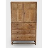 A Heal's Arts & Crafts limed oak linen press, the pair of four panelled doors enclosing three slides